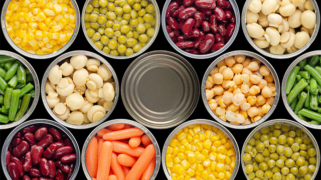 Opened cans of chickpeas green sprouts carrots corn peas beans mushrooms